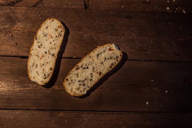 Rebanadas de pan marrón en una mesa de madera. Pan de testigo con salvado y cereales