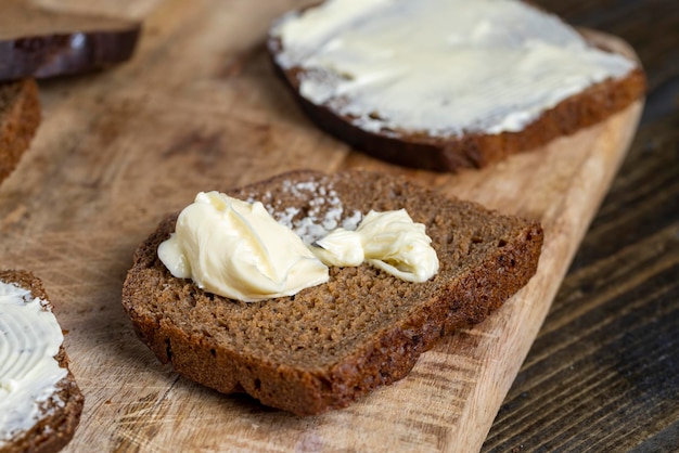 Rebanadas de pan de molde negro con mantequilla untada con leche