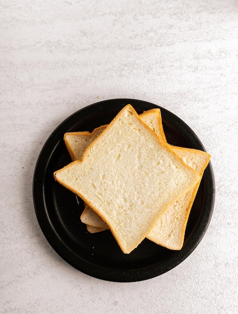 Rebanadas de pan en un plato negro Lay Flat