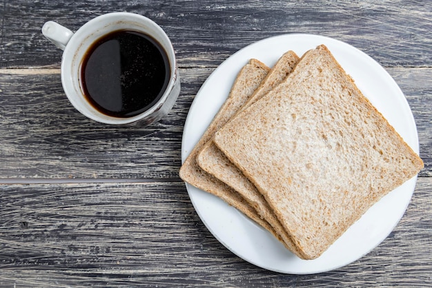 Rebanadas de pan en el plato y una taza de café.