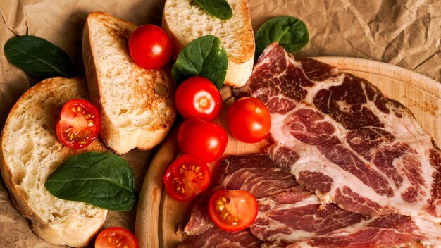 Rebanadas de pan, tomates cherry, espinacas y jamón. Ingredientes para un sándwich o bruschetta. Cocinar alimentos frescos y saludables