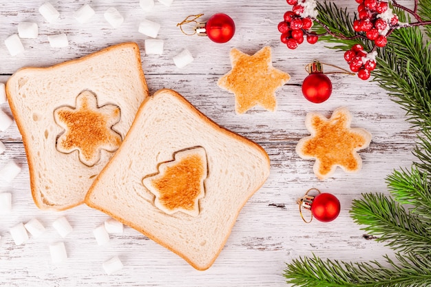 Rebanadas de pan tostado con corte tostado en forma de abeto y copo de nieve