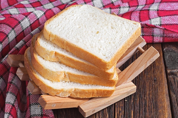 Rebanadas de pan tostado en mesa de madera con mantel