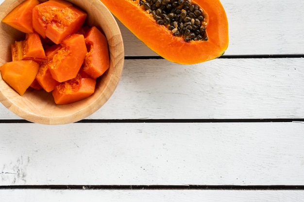 Rebanadas de papaya dulce en cuenco de madera en la tabla de madera. copia espacio