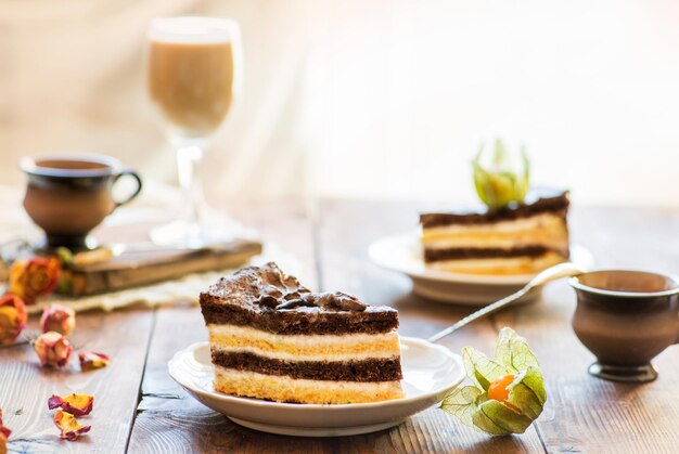 Rebanadas de pastel con crema con juego de té en una mesa servida