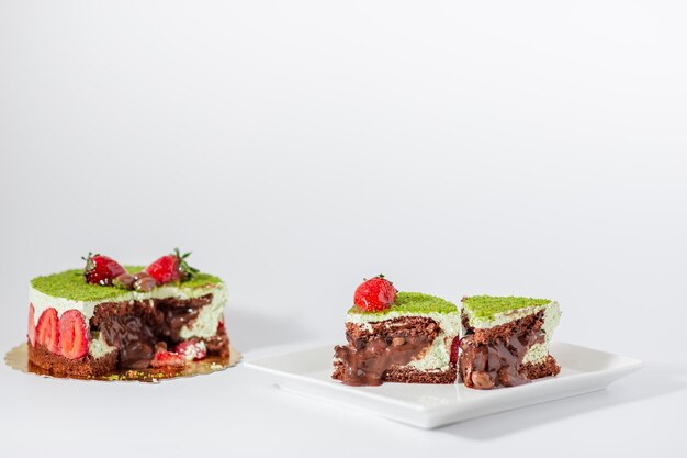 Rebanadas de pastel de fresa y pistacho sobre fondo blanco aislado