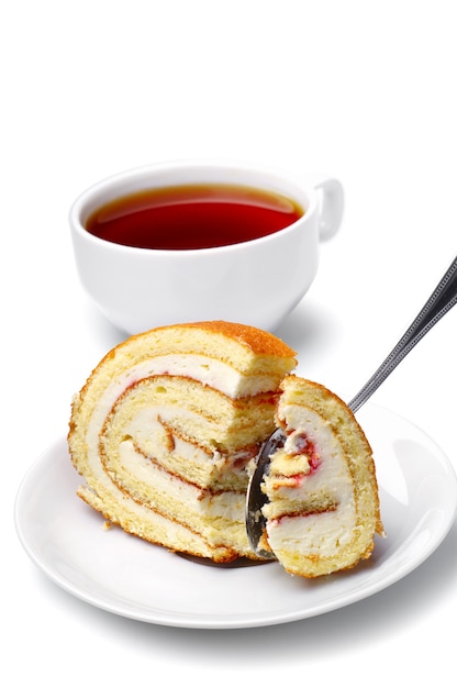 Rebanadas de pastel en un plato con una cuchara y una taza de té en blanco