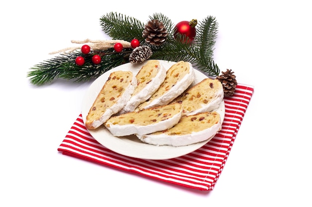 Rebanadas de pastel tradicional de navidad con mazapán y frutos secos en placa de cerámica