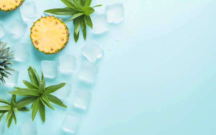 Rebanadas de piña con hojas de menta y cubos de hielo sobre fondo azul