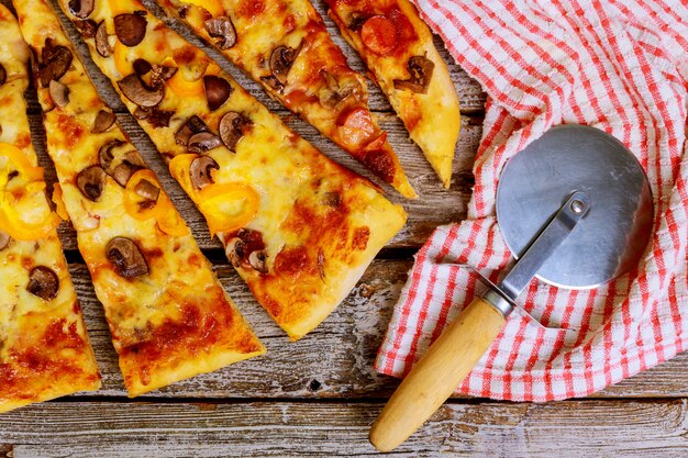 Rebanadas de pizza con diferentes ingredientes sobre un fondo de madera