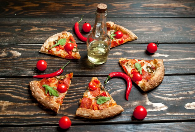 Rebanadas de pizza de pepperoni con ingredientes sobre fondo de madera