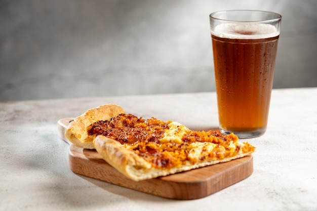 Foto rebanadas de pizza con un vaso de cerveza en la mesa