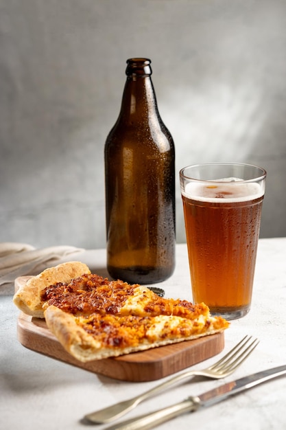 Foto rebanadas de pizza con un vaso de cerveza en la mesa