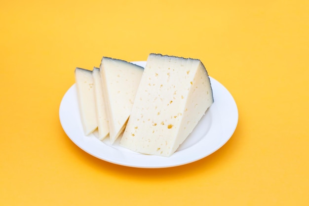 Rebanadas de queso en un plato pequeño blanco