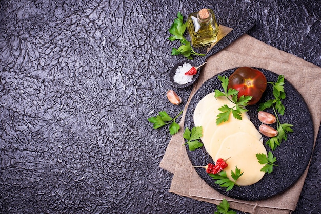 Rebanadas de queso sobre tabla de hierro fundido