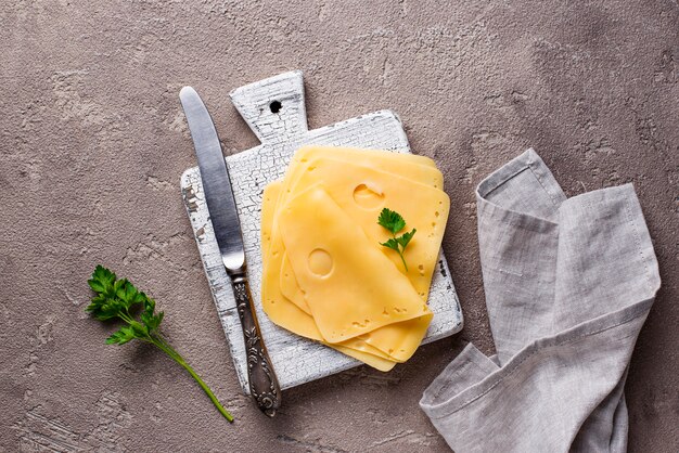 Rebanadas de queso en tabla para cortar