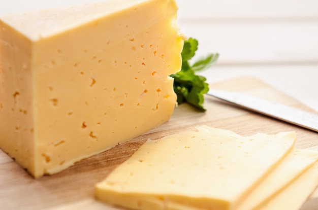 Rebanadas de queso en una tabla de cortar con