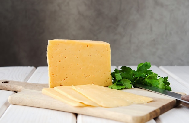 Rebanadas de queso en una tabla de cortar con