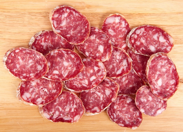 Rebanadas de salami italiano en tablero de madera