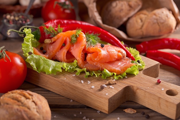 Rebanadas de salmón ahumado con eneldo, tomates