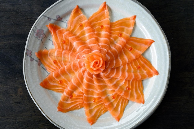 Rebanadas de sashimi de salmón crudo en plato de cerámica