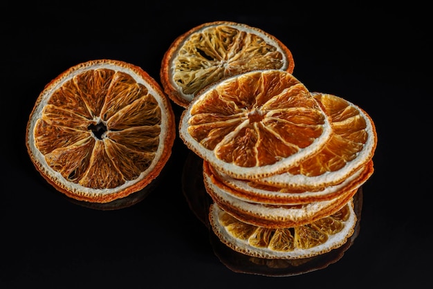 Rebanadas secas redondas de naranja natural sobre un fondo negro