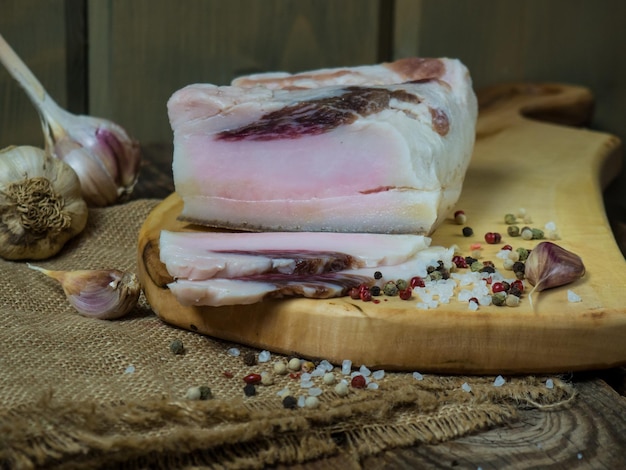 Rebanadas de tocino salado sobre un fondo de madera oscura Comida saludable con especias grasa salada manteca de cerdo