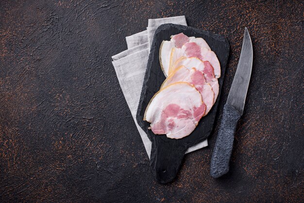 Rebanadas de tocino sobre tabla para cortar pizarra