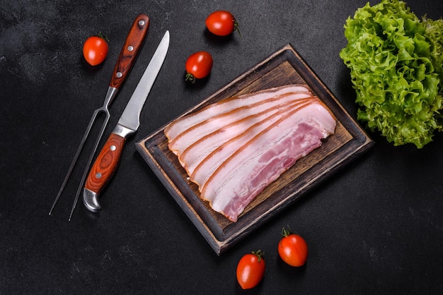 Rebanadas de tocino en una tabla de cortar de madera Carne de cerdo