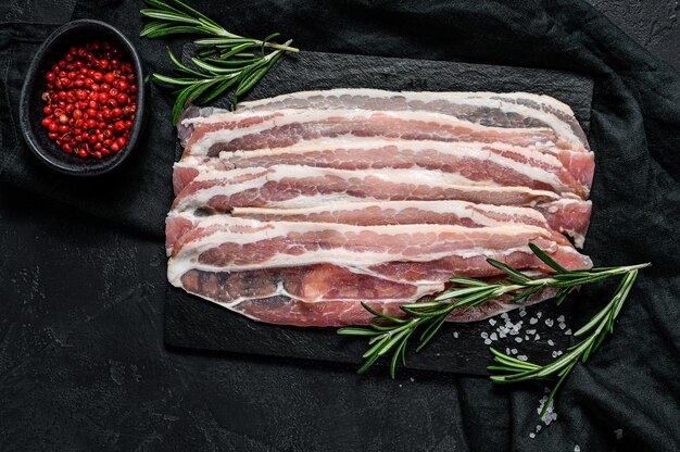 Rebanadas de tocino en una tabla para cortar piedra.