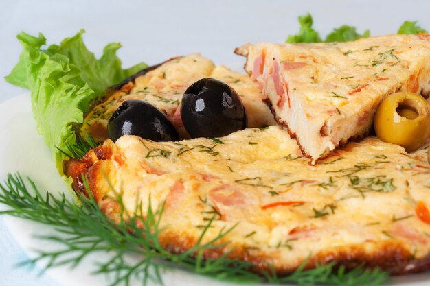 Rebanadas de tortilla con aceitunas en hoja de lechuga