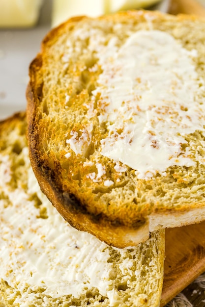 Rebanadas tostadas de pan de masa madre recién horneado con mantequilla.