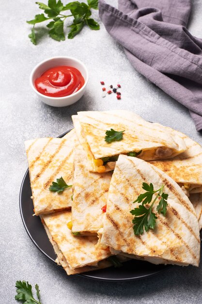 Rebanadas triangulares de una quesadilla mexicana con salsa.