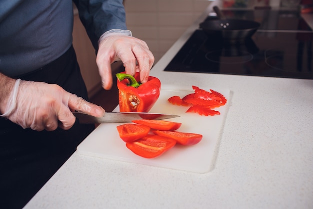 Rebanar pimiento rojo dulce en tabla de cortar