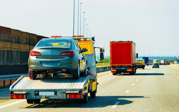 Foto reboque de reboque baixo com carro na estrada. auto veículo com transportador transportador transportador na garagem. logística de transporte europeu no transporte de trabalho de transporte. transporte na rodovia.