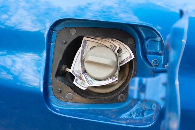 Foto la recarga de combustible del automóvil, algo de dinero en efectivo dentro del tanque de combustible, idea de gasolina cara