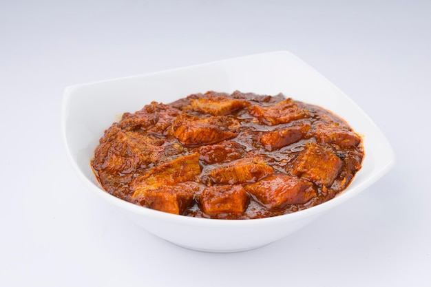Receita caseira de masala de carne ou curry disposta em tigela branca com fundo branco