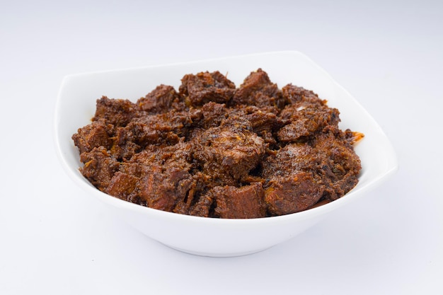 Receita caseira de masala de carne ou curry disposta em tigela branca com fundo branco