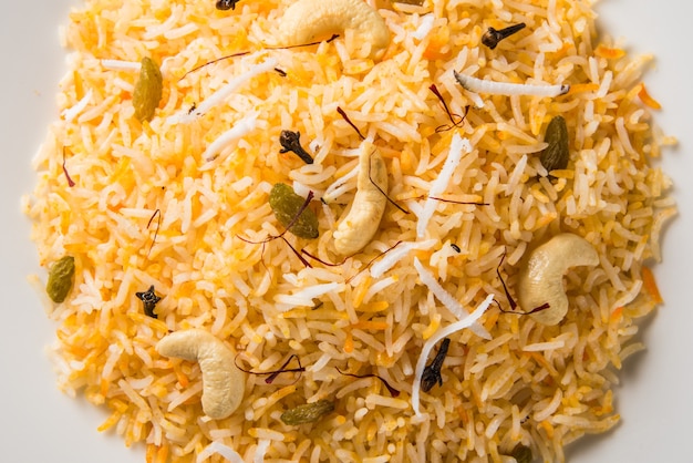 Receita de arroz doce de coco, também conhecida como narali bhat, feita com açafrão, caju, cravo e servida em uma tigela branca. comida popular konkani ou maharashtriana.