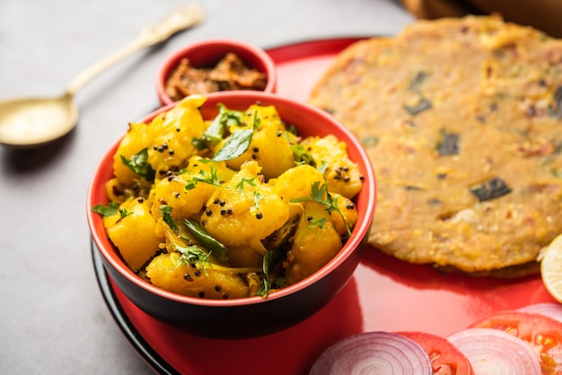 Foto receita de batata seca vegetal frita com cebola ou pyaj paratha, servida com picles de manga ou achar. comida indiana
