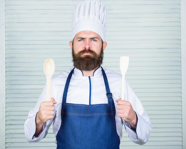 Receita de chef de homem barbudo sério Fazendo dieta homem de chef de alimentos orgânicos com ferramentas de cozinha de madeira Cozinha culinária Vitamina Culinária de comida saudável Hipster maduro com barba Posso ajudá-lo