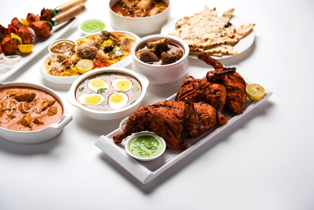 Receita de comida não vegetariana indiana variada servida em um grupo. Inclui frango ao curry, carne de carneiro Masala, Anda ou curry de ovo, frango à manteiga, biryani, tandoori murg, frango-tikka e naa, roti para o ramadã