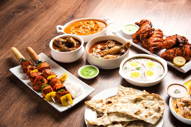 Receita de comida não vegetariana indiana variada servida em um grupo. Inclui frango ao curry, carne de carneiro Masala, Anda ou curry de ovo, frango à manteiga, biryani, tandoori murg, frango-tikka e naa, roti para o ramadã