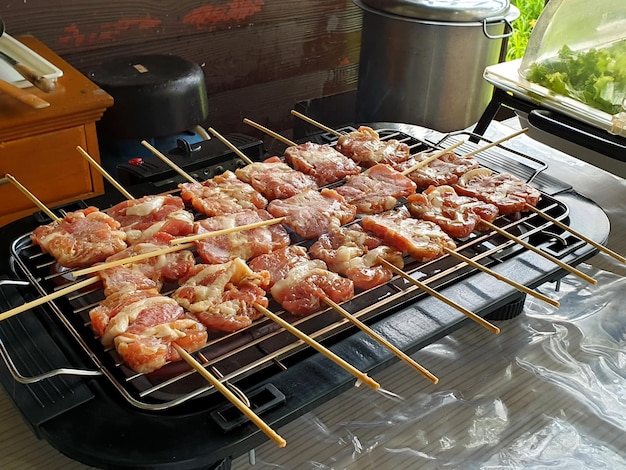 Receita de espetos de porco grelhados moo ping na grelha em chamas