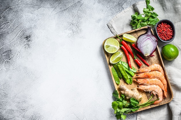 Receita e ingredientes Tom Kha Gai. Sopa de galinha galangal tailandesa no leite de coco. Fundo cinza. Vista do topo. Copie o espaço