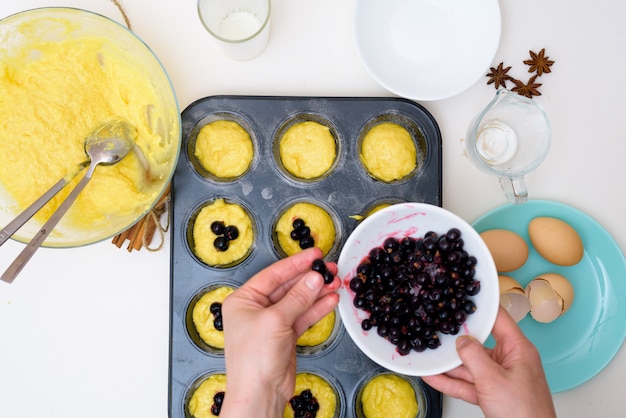 Receita passo a passo para bolos com groselhas. preparar a massa, misturando os ingredientes da farinha, manteiga, açúcar, ovos, baunilha, groselha. a vista do topo . cupcakes com recheio de groselha