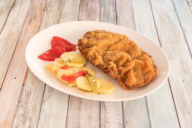 Receita popular de cachopo espanhol Lombo de boi com presunto e queijo empanado com farinha de rosca e ovo frito em óleo e guarnecido com batata assada com pimentão