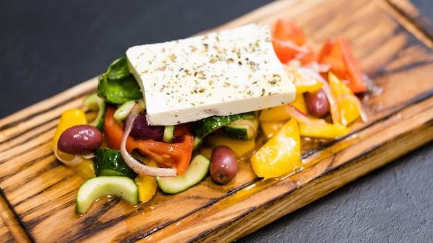 Receita tradicional de salada grega. Close up de legumes frescos, azeitonas Kalamata e queijo feta temperado com azeite extra virgem.