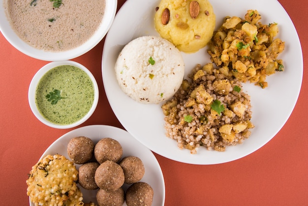 Foto receitas de jejum indianas ou comida upwas, para navratri, maha shivratri ou ekadasi ou chaturthi ou gauri vrat. servido em louças de cerâmica sobre fundo colorido ou madeira. foco seletivo