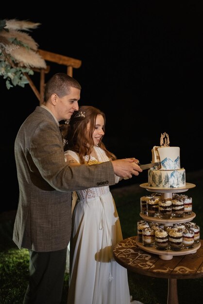 Recém-casados alegremente cortam risadas e provam o bolo de casamento